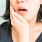 親知らずの抜歯後に痛みを感じる女性