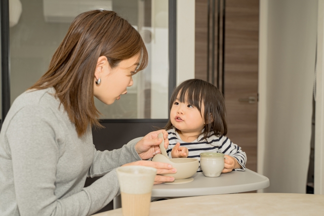 離乳食を上げるお母さんと子ども