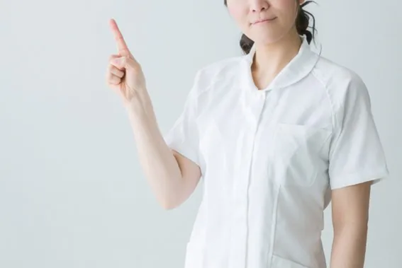 歯科衛生士が人差し指を上げている写真